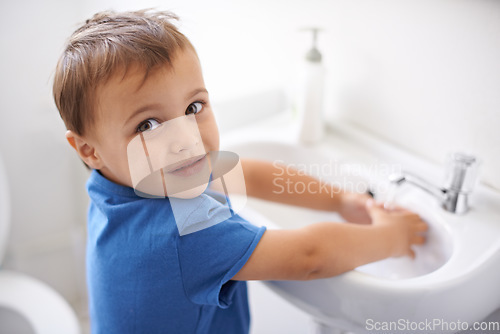 Image of Child, boy and washing hands in portrait, water and prevention of germs or bacteria in bathroom. Male person, kid and learning at basin or cleaning and sanitary, liquid and disinfection at home