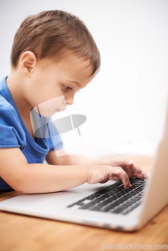 Image of Boy kid, laptop and typing in home, reading or search for movie, cartoon or elearning for development. Child, computer and click keyboard at desk in family house for education, study or online course