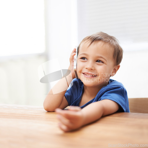 Image of Toddler, boy and phonecall at home, happiness and communication with technology. Table, calling and conversation for learning, cellphone and excited for child development, mobile and digital