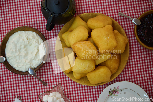 Image of An enticing top down view captures a delightful breakfast tableau, featuring freshly baked bread, delectable jam, and a comforting cup of tea a simple yet satisfying morning feast