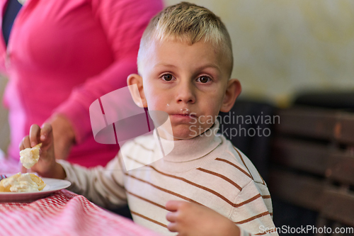 Image of A young boy savors his breakfast, indulging in a wholesome meal that radiates the joy of a nutritious start to the day