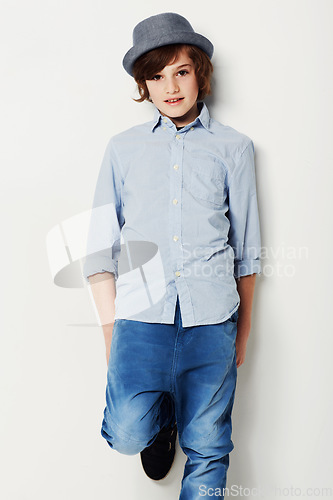 Image of Child, boy and portrait for style in studio, cool clothing and confident by white background. Happy male person, kid and hat by backdrop or pride for fashion, face and trendy outfit in childhood