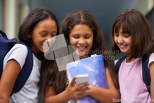 Image of Elementary school, friends and happy girls with phone for social media, digital education or download elearning tech. Diversity, young students or kids typing on mobile for studying, knowledge or app