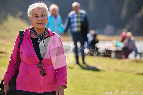 Image of A senior woman finds serenity and wellness as she strolls through nature, illustrating the beauty of maintaining an active and health-conscious lifestyle in her golden years