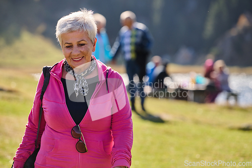 Image of A senior woman finds serenity and wellness as she strolls through nature, illustrating the beauty of maintaining an active and health-conscious lifestyle in her golden years