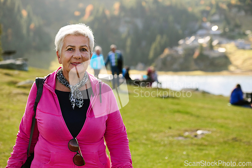 Image of A senior woman finds serenity and wellness as she strolls through nature, illustrating the beauty of maintaining an active and health-conscious lifestyle in her golden years