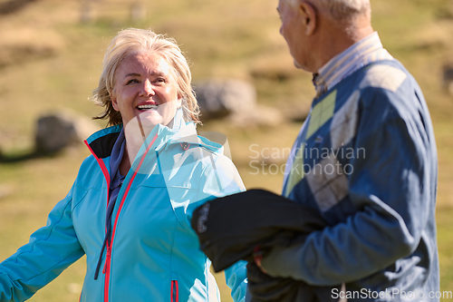 Image of Elderly couple strolling through the breathtaking beauty of nature, maintaining their vitality and serenity, embracing the joys of a health-conscious and harmonious lifestyle