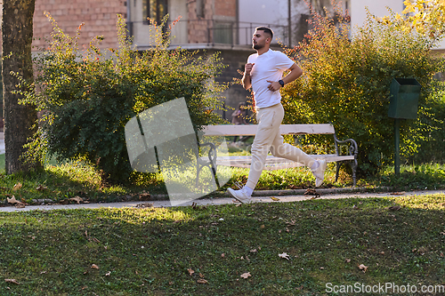 Image of A handsome man maintains his healthy lifestyle as he runs along beautiful natural trails, embodying the essence of fitness, wellness, and vitality in the midst of scenic outdoor surroundings.