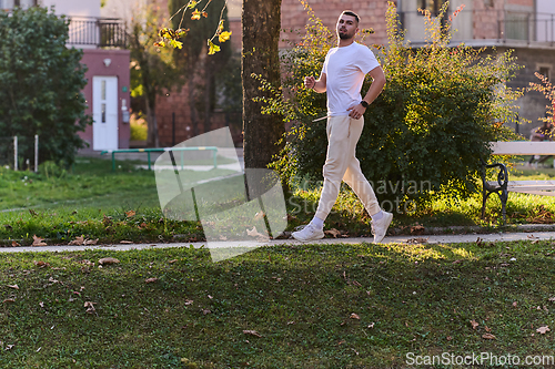 Image of A handsome man maintains his healthy lifestyle as he runs along beautiful natural trails, embodying the essence of fitness, wellness, and vitality in the midst of scenic outdoor surroundings.