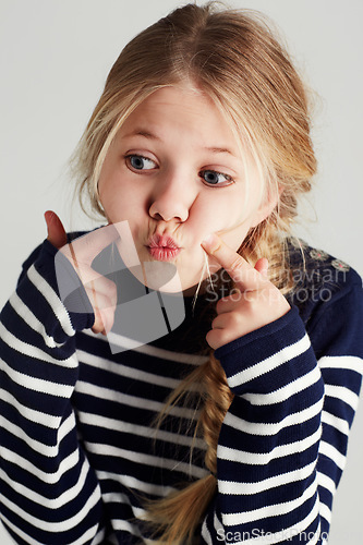 Image of Fashion, goofy and girl kid in a studio with casual, cool and stylish jersey outfit. Silly, comic and funny young child model with trendy youth style and positive attitude by gray background.