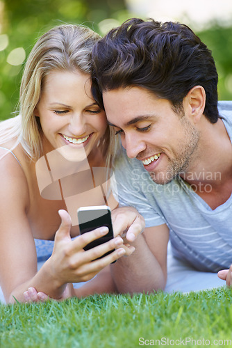 Image of Grass, phone or happy couple on social media in nature to relax together on outdoor holiday vacation. Smile, woman or man with funny meme or online post for bond with love, support or care on field