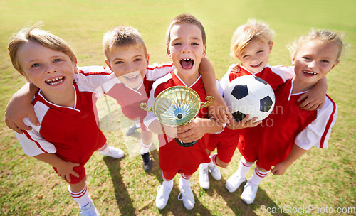 Image of Kids, soccer team and portrait with cup, boys and girls with victory, support or solidarity. Achievement, sports and friendship, together and happy for win, ready for game or physical activity