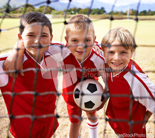Image of Kids, soccer team and portrait with smile, goal net and boys with teamwork, support or solidarity. Energy, sports and friendship, together and happy for win, ready for game and physical activity