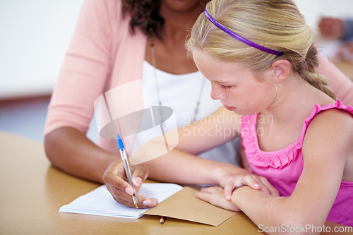 Image of Child, girl and student with teacher and writing in classroom, learning and helping for assessment or exam. Study, knowledge and education, people with notebook and pen for notes and info in class