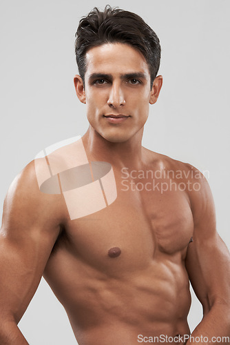 Image of Man, shirtless and portrait or bodybuilder pride in studio, abs and fitness by gray background. Male person, confident and strong core or muscular abdomen, face and results or progress from exercise