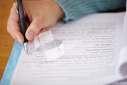 Image of Hand, pen and teacher mark paper, education and learning with closeup of test or assignment on desk in classroom. Person in class, exam or project, grade and feedback with results, notes and writing