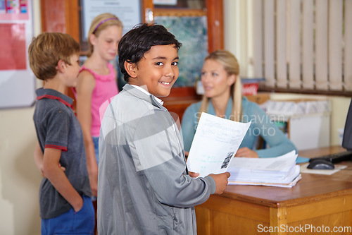 Image of Teacher, portrait or happy kid with paper in classroom for education, learning or tutoring at school. Boy, smile or educator helping a group of young students or children with paperwork for studying