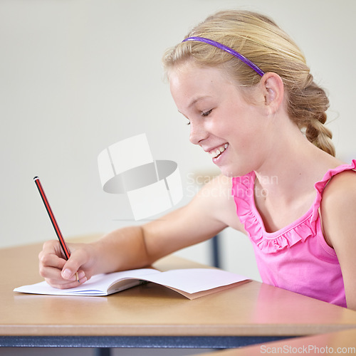 Image of Kid, school and smile for writing in classroom, studying lesson or learning knowledge at desk. Child, student or happy girl drawing in notebook of academic development, educational test or assessment
