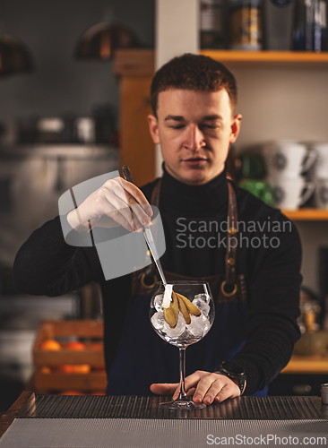 Image of Professional bartender decorates cocktail