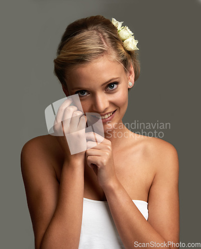 Image of Portrait, cosmetics and woman with smile, beauty and flowers isolated on grey studio background. Face, person and model with texture, skincare and luxury with aesthetic, glowing and healthy skin