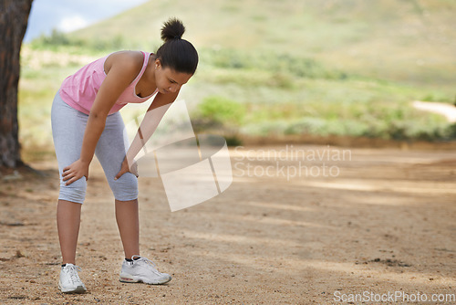 Image of Break, tired runner or woman in countryside running exercise, cardio workout or training for fitness. Athlete, breathing or sports girl with fatigue relaxing or resting to relax in park in nature