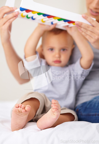 Image of Abacus, portrait and baby with mother playing, learning and teaching for child development on bed. Bonding, toy and mom teaching kid, infant or toddler math counting in bedroom at modern home.