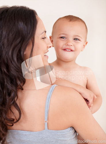 Image of Family, happy and mother with child on a white background for bonding, relationship and relax together. Love, youth and portrait of mom carrying kid for growth, playing and development in studio