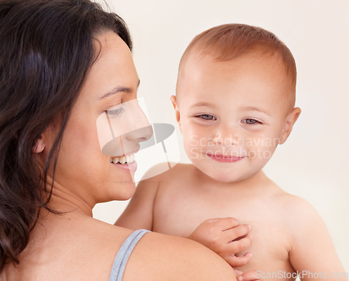 Image of Family, love and mother with baby on a white background for bonding, relationship and relax together. Happy, youth and mom carrying kid for childcare wellness, playing and development in studio