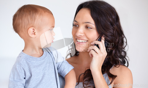 Image of Mom holding toddler in home with phone call, smile and child care with support in morning. Happy woman, baby boy and bonding together in bedroom with chat on cellphone, multitasking and mothers love.