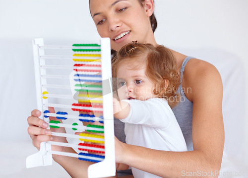 Image of Abacus, playing and girl baby with mother for math, learning and teaching for child development on bed. Bonding, toy and young mom with kid, infant or toddler with counting in bedroom at home.