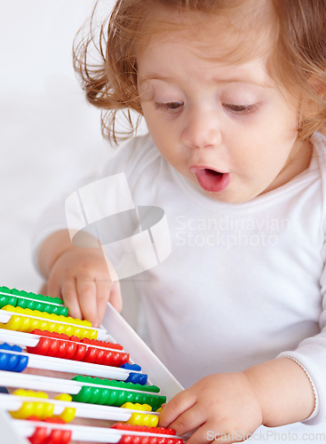 Image of Abacus, surprise and girl baby learning, playing and teaching for child development on bed. Maths, toy and closeup of young kid, infant or toddler counting for education in bedroom at modern home.