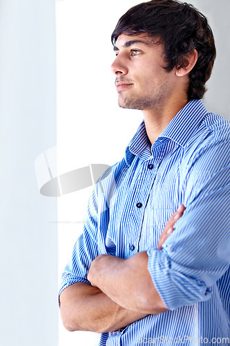 Image of Young man, office and looking out window with arms crossed in thinking, confidence or contemplating. Face of handsome male person or employee in wonder or thought for company vision at workplace