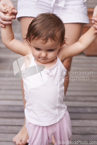 Image of Mother, outdoors and baby learning to walk, support and teaching toddler for child development or growth. Mommy, girl and trust in parent and childcare, security and education for skills on deck