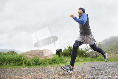 Image of Trail, runner and man running in nature training, cardio exercise and endurance workout for wellness. Sports, fitness or healthy male athlete on fast jog on mountain outdoors with speed of action