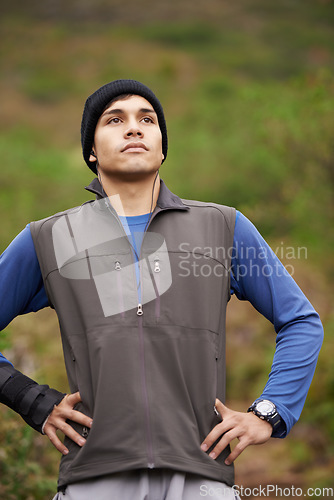 Image of Man, hiker and thinking for adventure, earphones and listening to podcast, exercise and workout. Hiking, fitness and climber for training, forest and nature to explore, hobby and health in outdoors