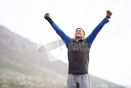 Image of Man, hiker and winner on mountain peak and happy with progress, exercise and victory. Hiking, fitness and climber for training, achievement and nature to explore, success and health in outdoors