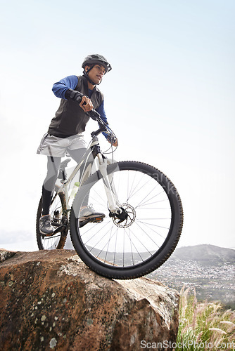 Image of Man, mountain bike and off road cycling on nature adventure or fitness in outdoor extreme sport. Male person or cyclist on bicycle for cardio or dirt path terrain on cliff for exercise with blue sky