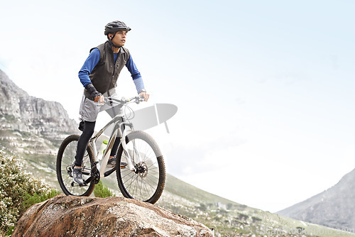 Image of Man, mountain bike and off road cycling with mockup space on nature adventure or fitness in outdoor extreme sport. Male person or cyclist on bicycle for cardio on cliff hill in exercise with blue sky
