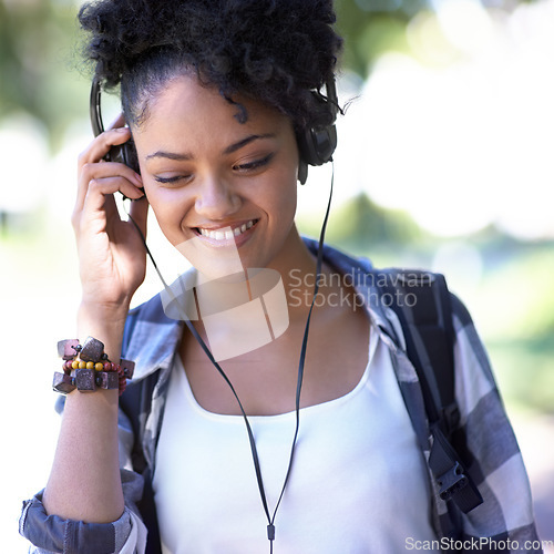 Image of Woman, headphones and music on university campus for entertainment, listening or education. Female person, smile and backpack at college for scholarship student or subscription, track or streaming