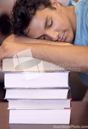 Image of Student man, sleeping and stack of books for education, development or exhausted with fatigue at college library. Person, learning and rest with burnout, tired or mental health for exam at university