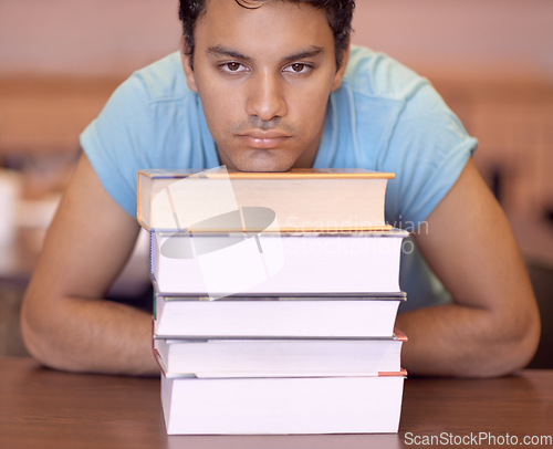 Image of Student man, bored and stack of books for education, development or tired at college library. Person, learning or knowledge with anxiety, burnout or thinking for research with brain fog at university