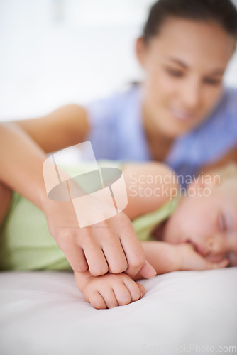 Image of Hands, sleeping and mother with baby on bed for bonding, relax and sweet cute relationship. Happy, smile and young mom watching girl child, kid or toddler taking a nap in bedroom or nursery at home.