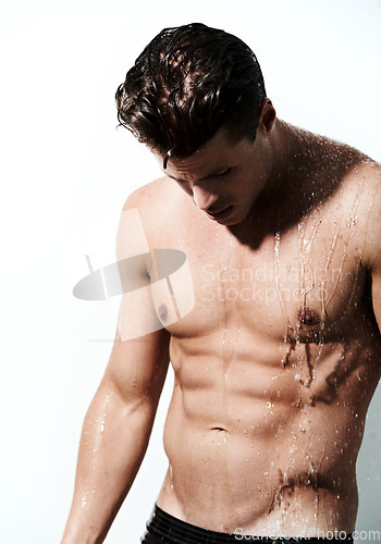 Image of Shower, shirtless and body of man with water for washing, cleaning and skincare wellness. Sexy, hot and muscular male model with grooming and hygiene for healthy skin by white studio background.