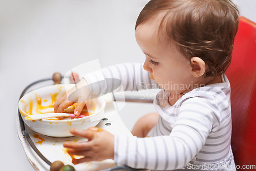 Image of Eating, puree and girl baby in chair with vegetable food for child development at home. Cute, nutrition and hungry young kid or toddler enjoying healthy lunch, dinner or supper meal at house.