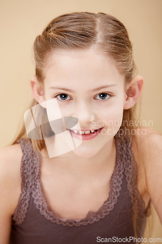 Image of Child, portrait and smile in studio for youth confidence on brown background as mockup space, innocence or relax. Female person, model and face of young student for positive mood, cute or natural