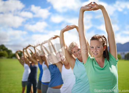 Image of Women stretching arms, outdoor for exercise on sports field and team in fitness class. Health, portrait and training together, young athlete group workout in park and physical activity with warm up