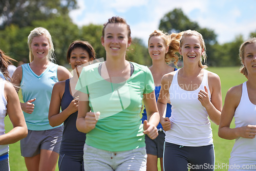 Image of Women, fitness in group and running in park for cardio, health and wellness with training together for race. Marathon, workout and energy on sports field, runner team with smile and exercise outdoor