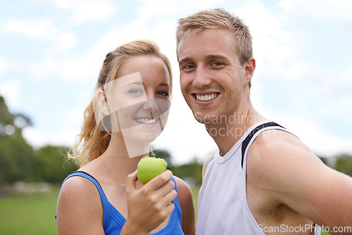 Image of Couple, sport and portrait with apple, fitness and exercise on a field with a smile and wellness. Happy, healthy and athlete outdoor with fruit, nutrition and health together for workout and training