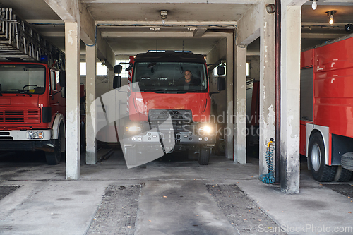 Image of A dedicated firefighter preparing a modern firetruck for deployment to hazardous fire-stricken areas, demonstrating readiness and commitment to emergency response