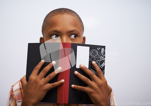 Image of Student, classroom and hide face with book to read in front for classmates, shy and learning. Elementary school, boy and prepared oral with workbook, childhood development and academic education